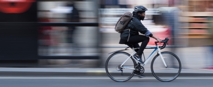 Person riding a bicycle with motion blur effect on the background.