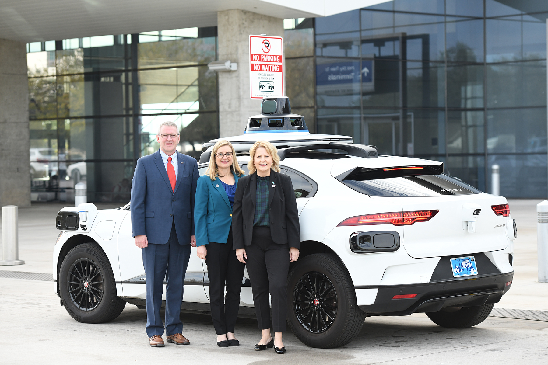 Vips standing in front of a Waymo car